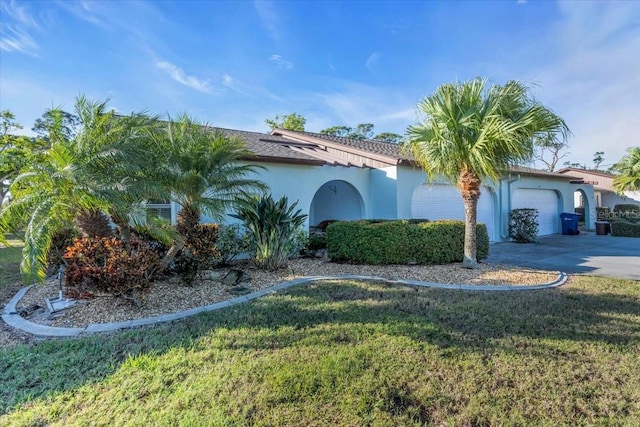 mediterranean / spanish home featuring a front lawn and a garage