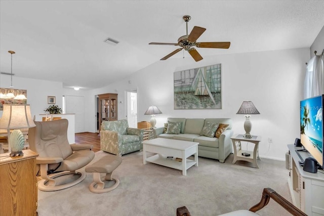 living room featuring vaulted ceiling, light carpet, and ceiling fan with notable chandelier