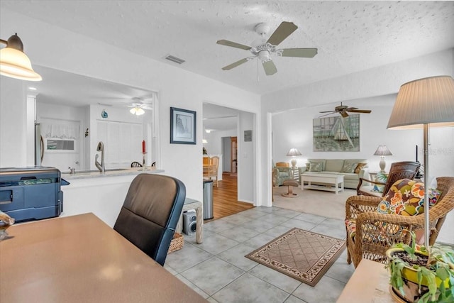 office featuring sink, light tile patterned flooring, and a textured ceiling