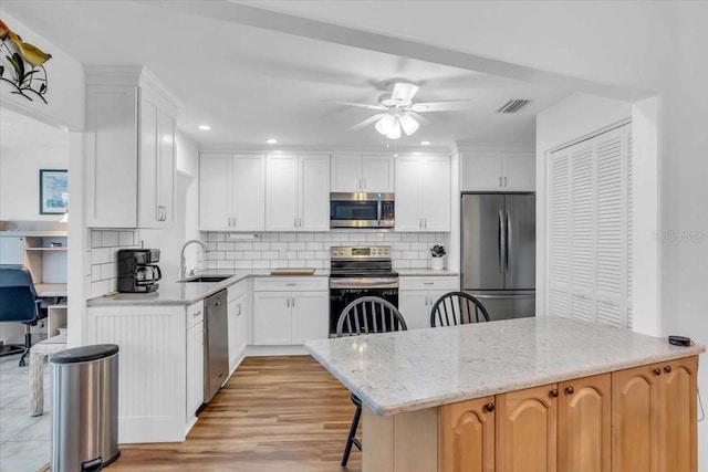 kitchen featuring a center island, appliances with stainless steel finishes, and white cabinetry