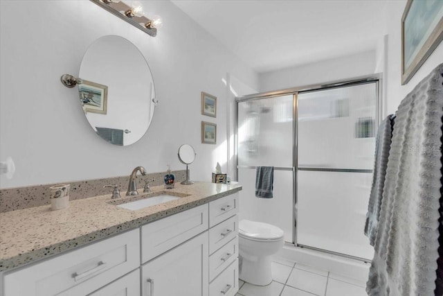 bathroom with vanity, toilet, walk in shower, and tile patterned floors