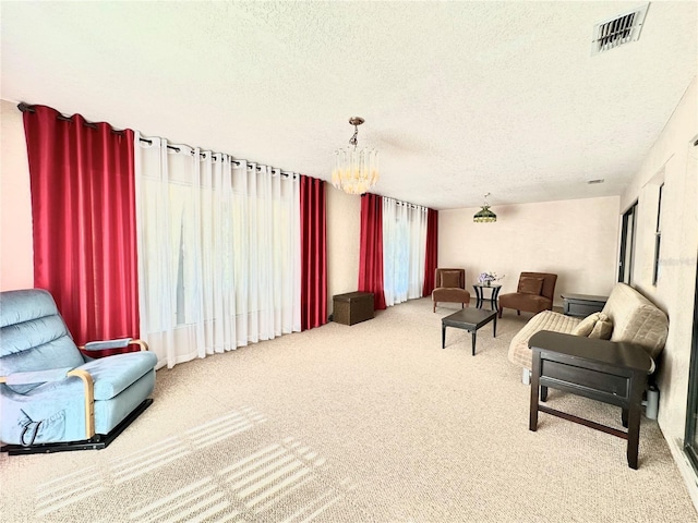 living room with a textured ceiling, carpet, and a chandelier