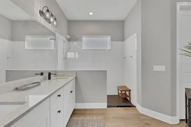 bathroom with vanity and tiled shower