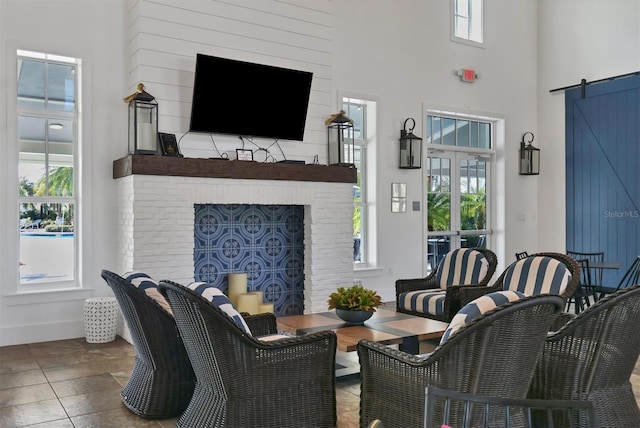 living room featuring a barn door and a towering ceiling