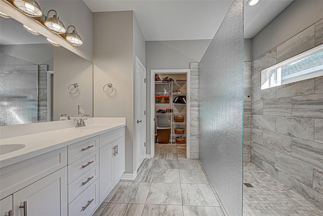 bathroom with vanity and a tile shower