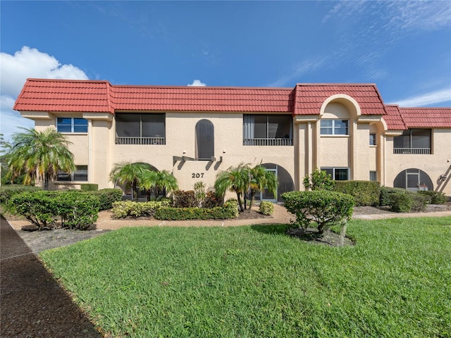 mediterranean / spanish-style home with a front yard