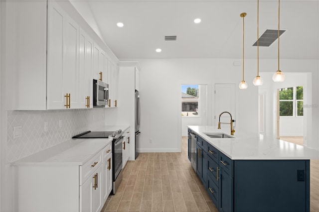 kitchen with appliances with stainless steel finishes, blue cabinetry, white cabinets, decorative light fixtures, and sink