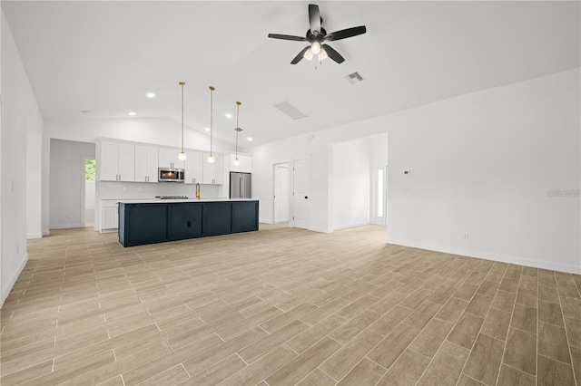 unfurnished living room featuring ceiling fan, lofted ceiling, and sink