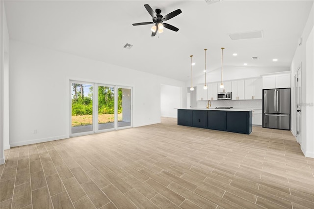 unfurnished living room with lofted ceiling, ceiling fan, and light hardwood / wood-style floors