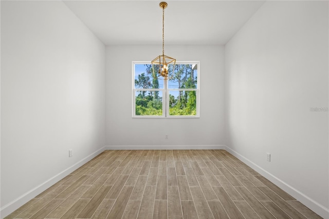 empty room featuring an inviting chandelier and wood-type flooring