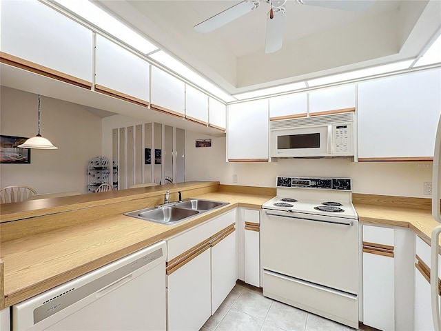 kitchen with white appliances, white cabinetry, light countertops, and a sink