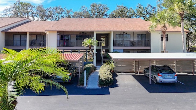 exterior space featuring covered parking, stairway, and stucco siding