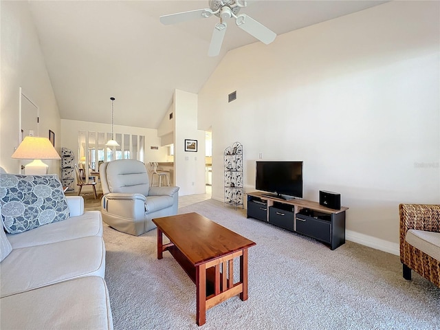 living room featuring baseboards, high vaulted ceiling, a ceiling fan, and light colored carpet