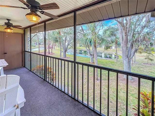 unfurnished sunroom featuring a ceiling fan