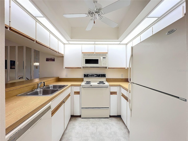 kitchen featuring white appliances, white cabinetry, light countertops, and a sink