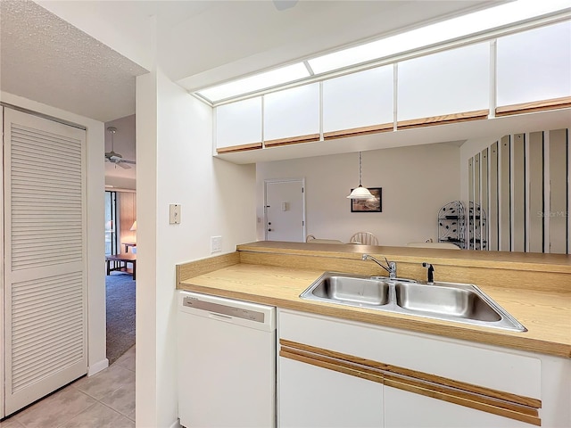 kitchen featuring light countertops, white dishwasher, a sink, and pendant lighting