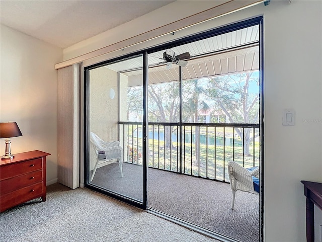 doorway featuring carpet floors and ceiling fan