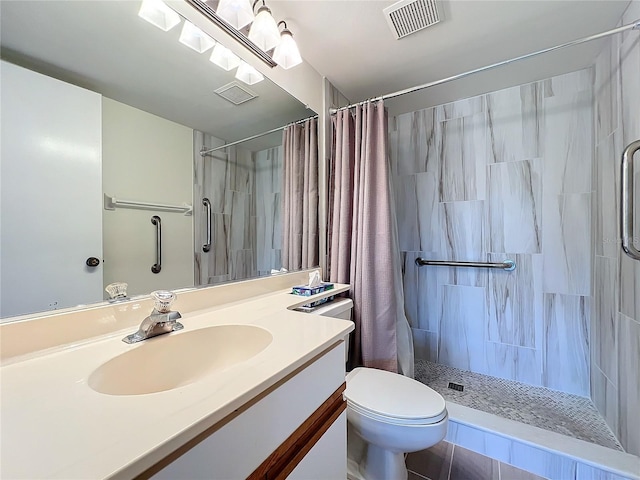 full bath featuring toilet, vanity, a tile shower, and visible vents