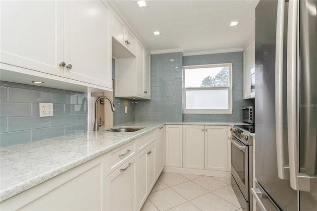 kitchen featuring sink, white cabinetry, backsplash, and stainless steel appliances