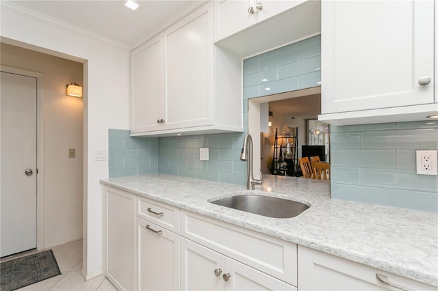 kitchen featuring ornamental molding, white cabinets, tasteful backsplash, and sink