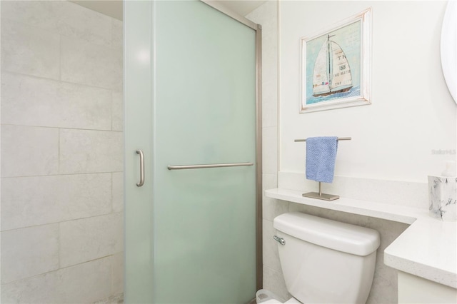 bathroom featuring walk in shower, vanity, and toilet