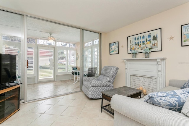 living room with ceiling fan, light tile patterned floors, and a fireplace