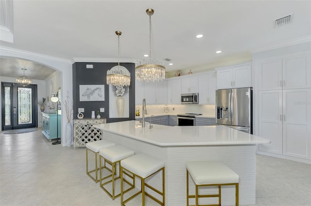 kitchen featuring white cabinetry, pendant lighting, a breakfast bar area, and stainless steel appliances