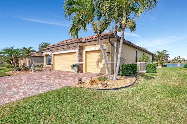 view of front of property with a garage, central AC, and a front lawn