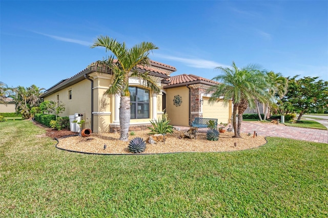 mediterranean / spanish home featuring a garage and a front yard