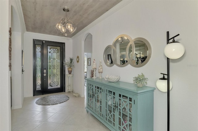 entryway with ornamental molding and a chandelier