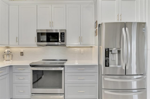 kitchen featuring white cabinets, appliances with stainless steel finishes, and backsplash