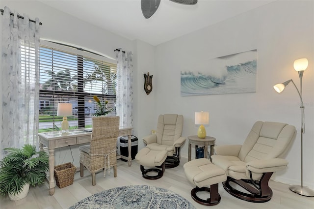 living area with light wood-type flooring and ceiling fan