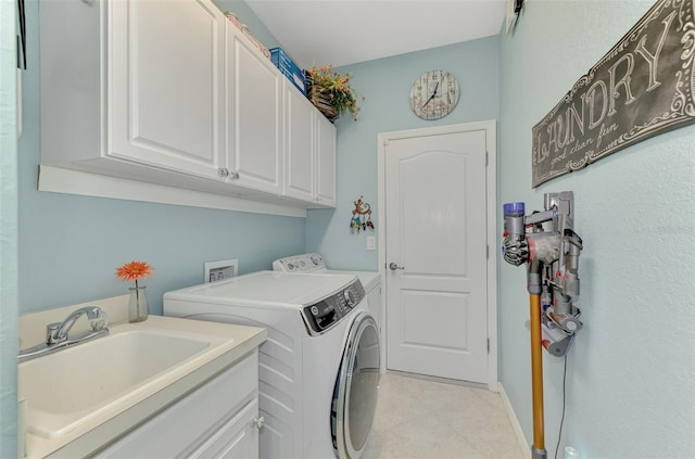 laundry area featuring cabinets, washer and dryer, and sink