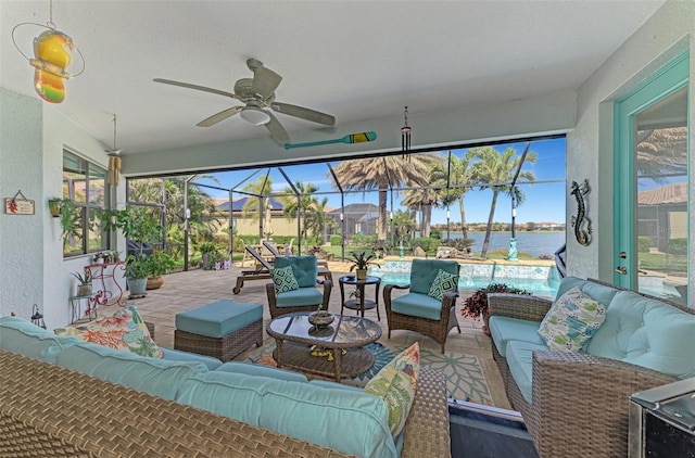 sunroom featuring a water view and ceiling fan