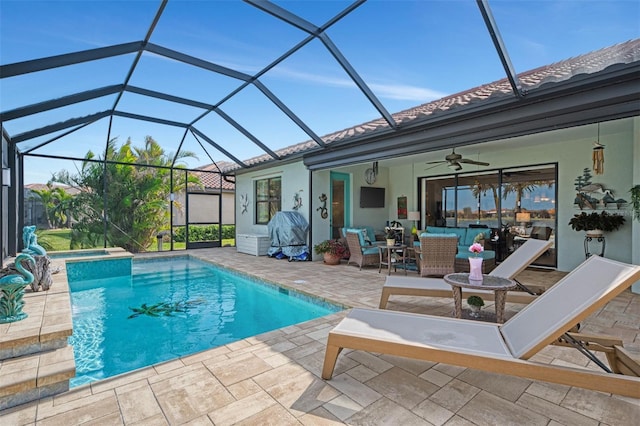 view of swimming pool featuring ceiling fan, outdoor lounge area, a patio area, and glass enclosure