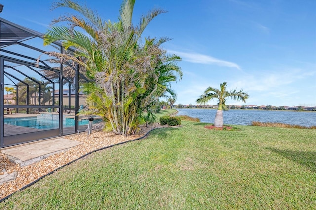 view of yard with a lanai and a water view