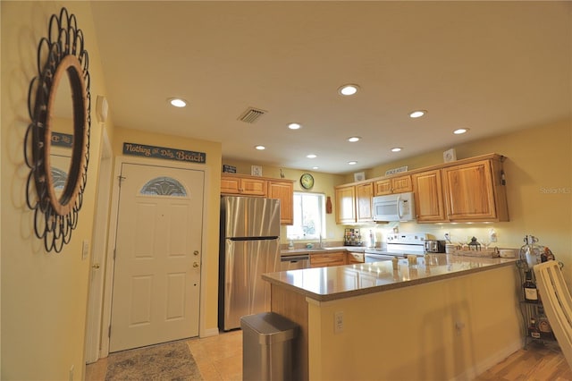 kitchen featuring appliances with stainless steel finishes, kitchen peninsula, and dark stone counters