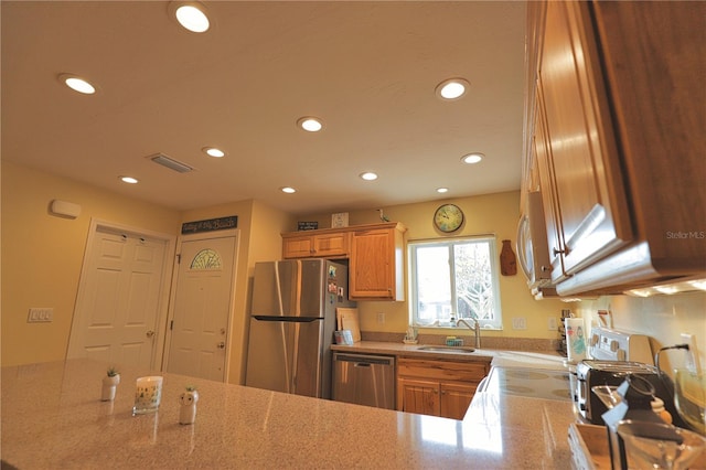 kitchen featuring stainless steel appliances, kitchen peninsula, and sink