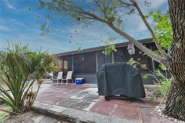 view of patio with a grill and a sunroom