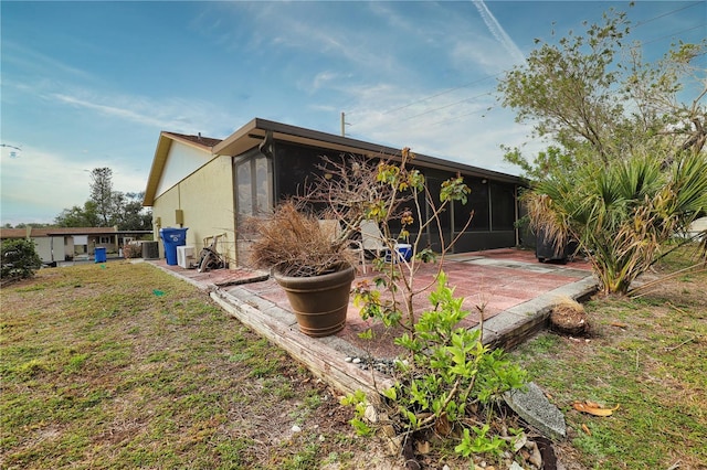 back of house featuring central AC, a sunroom, and a patio