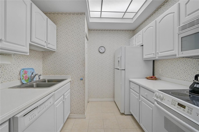 kitchen featuring light tile patterned floors, sink, white appliances, and white cabinetry