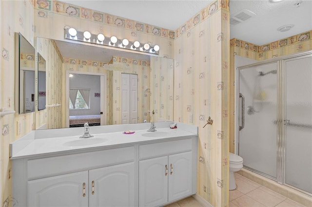 bathroom featuring walk in shower, vanity, tile patterned flooring, and toilet