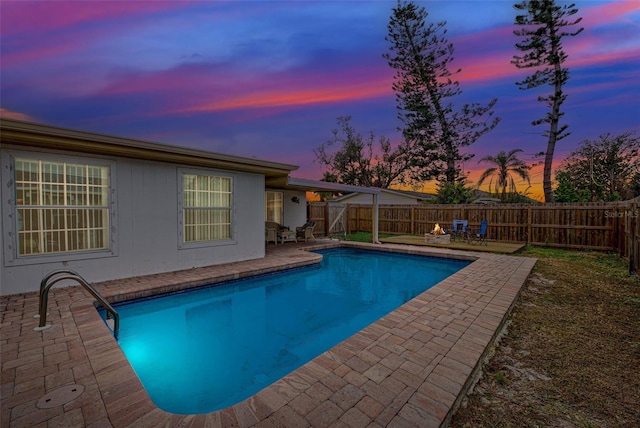 pool at dusk featuring a patio