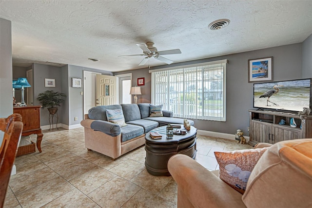 living room featuring a textured ceiling, ceiling fan, and light tile patterned floors