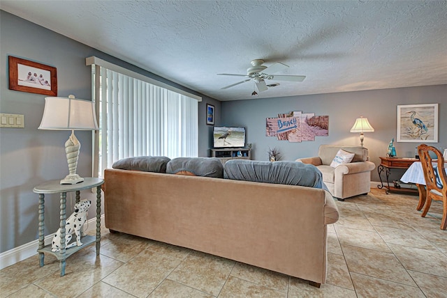 tiled living room with ceiling fan and a textured ceiling