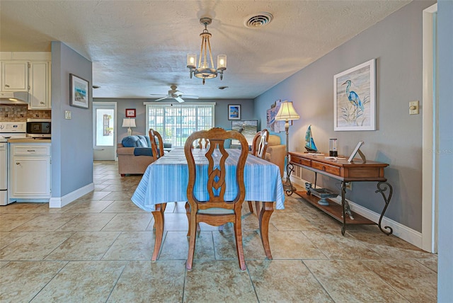 dining room featuring ceiling fan with notable chandelier, a textured ceiling, and light tile patterned floors