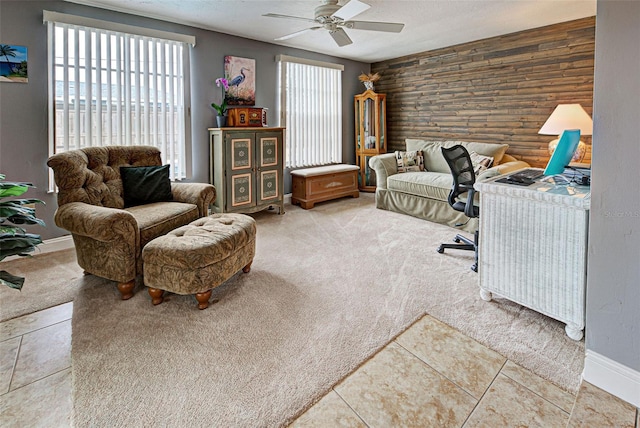 office area with rustic walls, tile patterned flooring, and ceiling fan