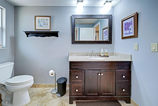 bathroom featuring toilet, vanity, and tile patterned floors