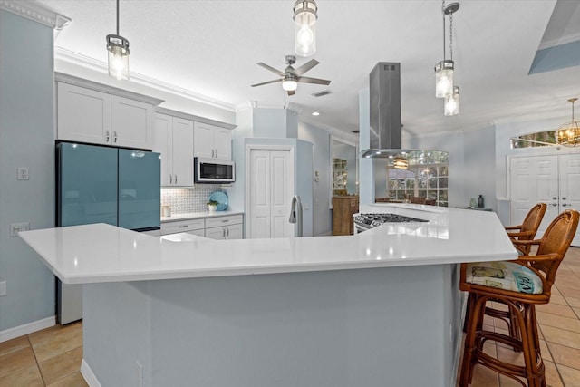 kitchen with a kitchen breakfast bar, island range hood, tasteful backsplash, and a spacious island