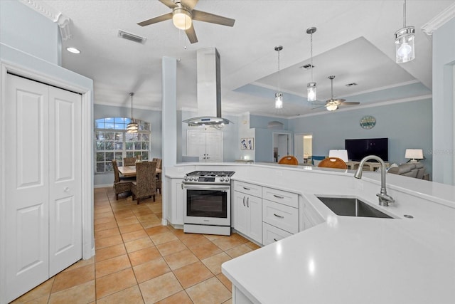 kitchen with sink, gas range, pendant lighting, and island range hood